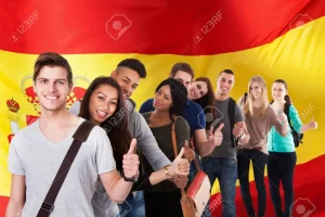 37024882 grupo de feliz estudiantes etnicos multi coloca delante del bandera de espana mostrando el pulgar